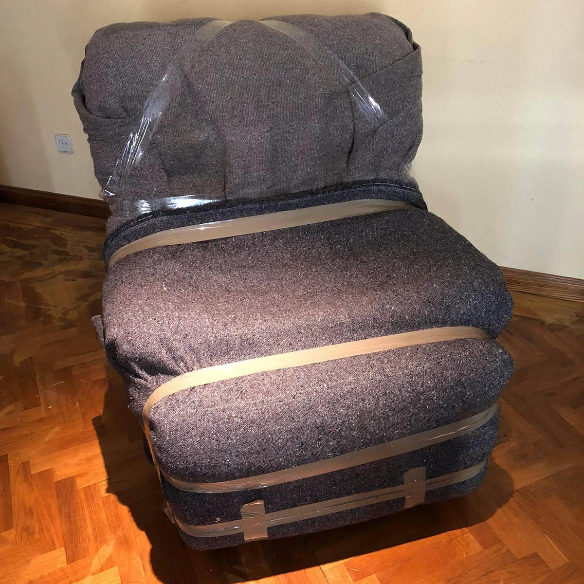 El mismo sillón envuelto en manta y cinta de embalar
