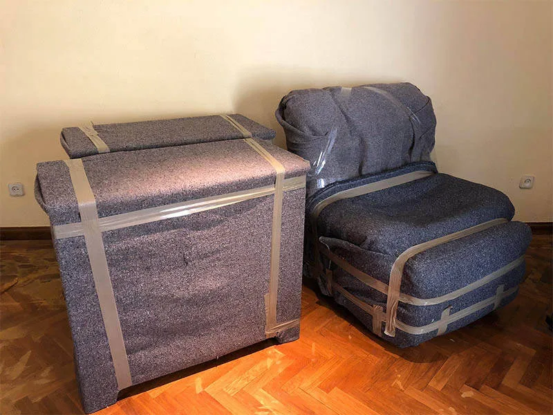 Arcón y sillón envueltos en manta y precintados